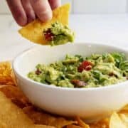 dipping guacamole with a tortilla chip