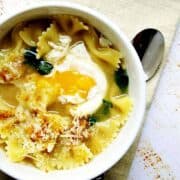 Egg-Farfalle-Bowtie-Pasta-Arugula-Soup served in a white bowl featured