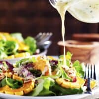 pouring dressing over Delicata Squash Salad