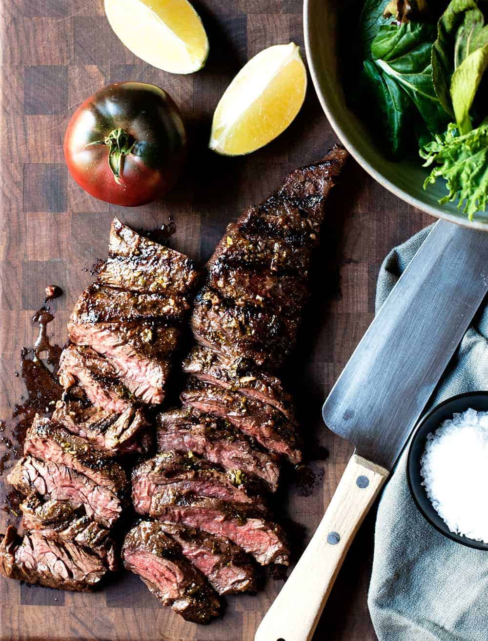 Carne Asada thinly cut on a cutting board and ready to serve.