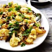 Roasted-Cauliflower-with-Pine-Nuts-and-Raisins served on a platter