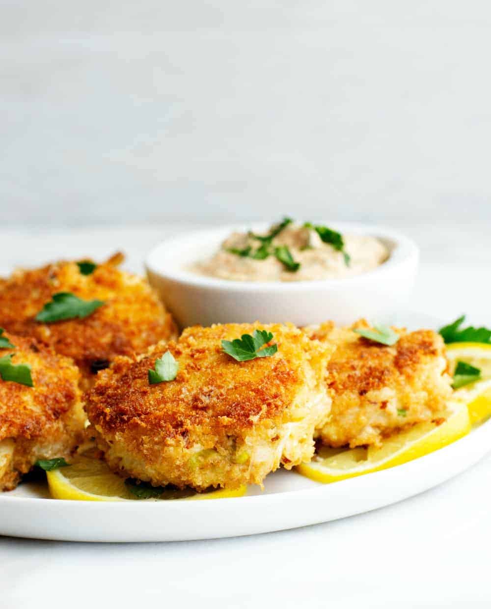 Crab Cakes served on a white plate with lemon slices