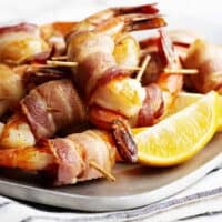 Bacon Wrapped Shrimp served on a stainless platter featured