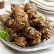 lamb kabobs served on a stainless platter