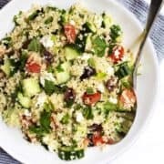 Quinoa Tabbouleh Salad served in a white bowl with stainless spoon