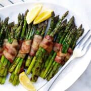 Grilled Bacon Wrapped Asparagus on a white platter