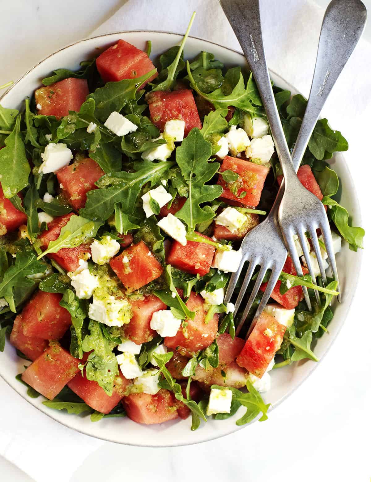 Watermelon and Arugula Salad with Feta Cheese in a ceramic bowl photographed from above