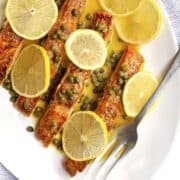 Salmon Piccata served on a white oval platter