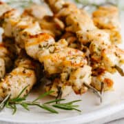 Chicken Kabobs cooked in the oven served on a white oval platter with a linen napkin