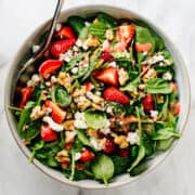 Spinach Strawberry Walnut Salad served in a light gray ceramic bowl