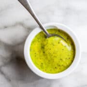 Pesto Aioli in a white bowl with a spoon in it
