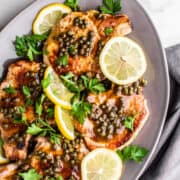 Pork Piccata served on a gray oval platter.