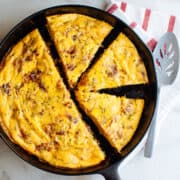 potato frittata sliced into wedges in a cast iron skillet photographed from above.