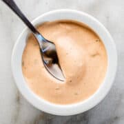 chipotle crema served in a small white bowl with a serving spoon.