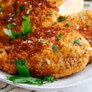 Italian chicken cutlets served on a white oval platter.