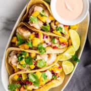 shrimp tacos with mango salsa served on an oval platter