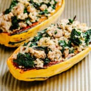 Stuffed Delicata Squash on a rimmed baking sheet.