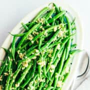 Garlic Butter Green Beans on oval platter photographed from overhead.