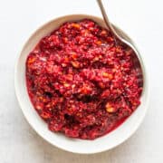 Cranberry Orange Relish served in a white bowl with a silver spoon.