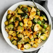 Roasted Potatoes and Brussels Sprouts served in a white bowl and photographed from above.