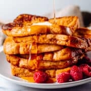 pouring syrup on stack of Brioche French Toast.