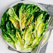 Little Gem Salad served on a round white platter and photographed from overhead.