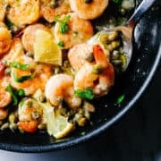 Shrimp Piccata on a spoon in a skillet.