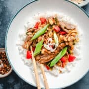 Kung Pao Beef served in a white ceramic bowl with wooden chopsticks and peanuts in a bowl and photographed from the top.