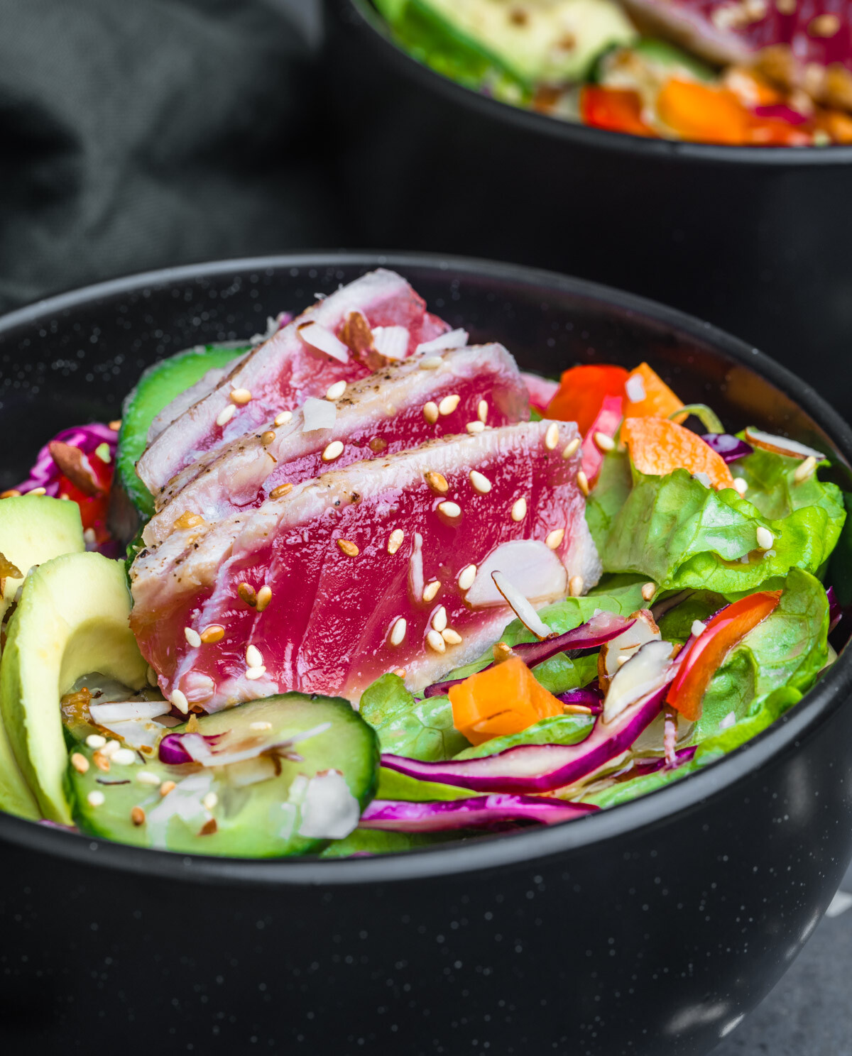 Close up shot of Ahi Tuna Salad served in a black bowl and photographed at an angle.