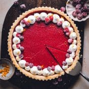 Lifting a single slice from a Cranberry Curd Tart photographed from the top.