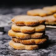 Biscochitos stacked on a gray granite surface.