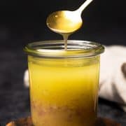 Shallot Vinaigrette in a small jar spooned by a gold spoon.