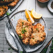 Baked Chicken Cutlets served on a speckled ceramic plate photographed from the top.