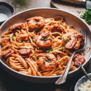 Cajun Shrimp and Sausage Pasta photographed at an angle in a light gray ceramic bowl.