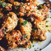 Garlic Parmesan Wings served on a light gray ceramic plate and photographed at an angle.