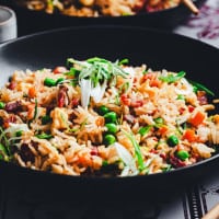 Bacon Fried Rice served in a black bowl and photographed at an angle.