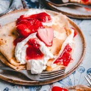 Strawberry Crepes served on ceramic plates and photographed at an angle.