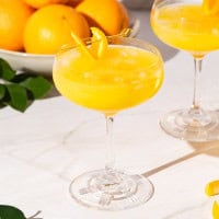 Agua de Valencia served in two coupe glasses over ice.