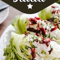 Three iceberg lettuce wedges topped with creamy dressing, chopped crispy bacon, and chopped chives, served on a white plate. The top of the image reads "Classic Wedge Salad.