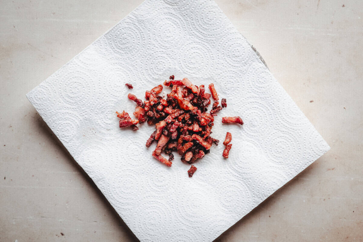 cooked chopped crispy bacon draining on a paper towel